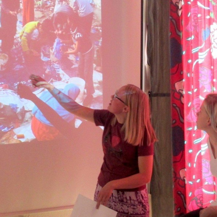 Þarna er hún að útskýra vatns- og þvottaaðstöðuna fyrir nemendum.