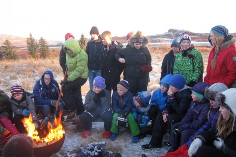 Nemendur hjúfruðu sig saman við eldinn í kuldanum